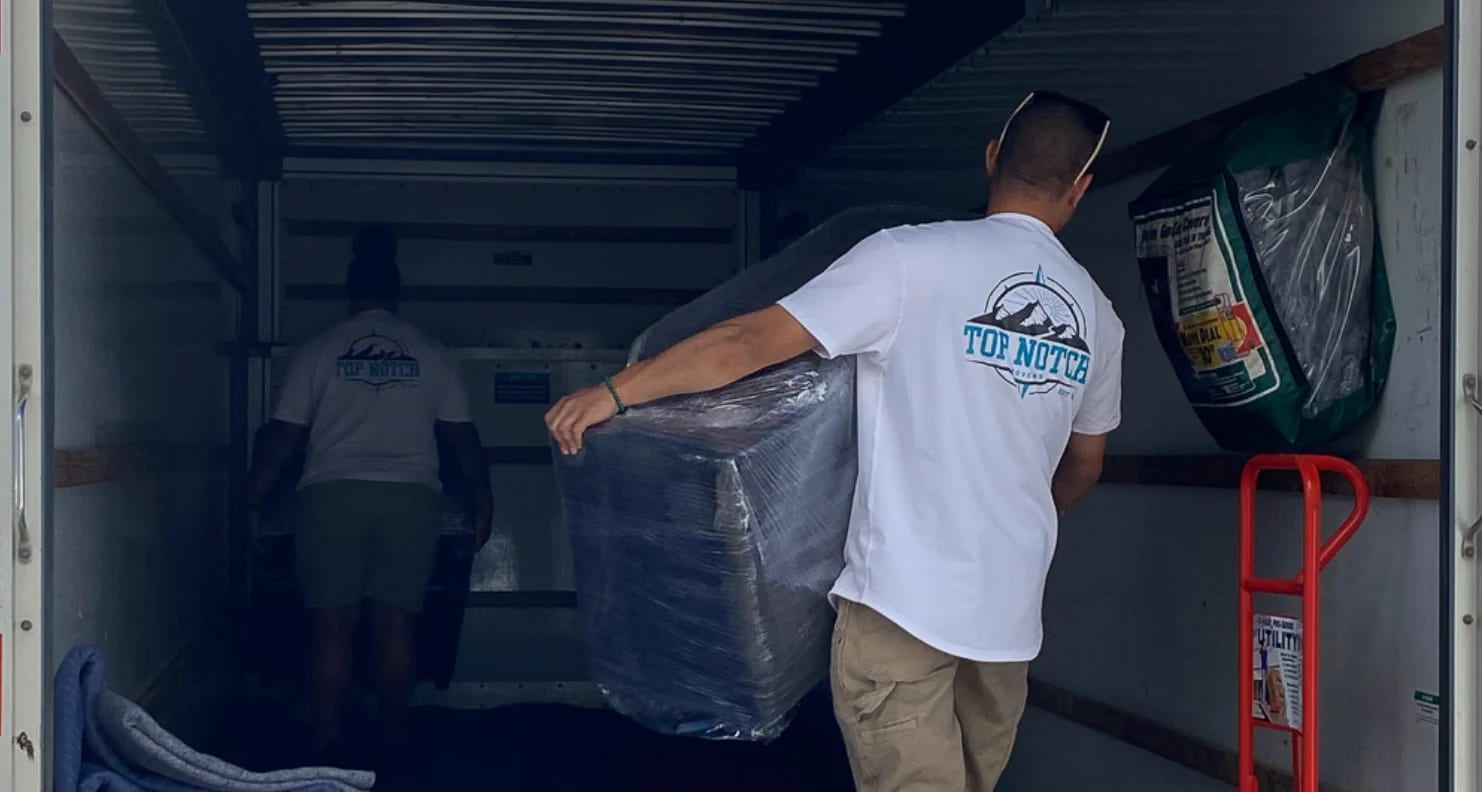Top Notch mover carrying a wrapped piece into the truck