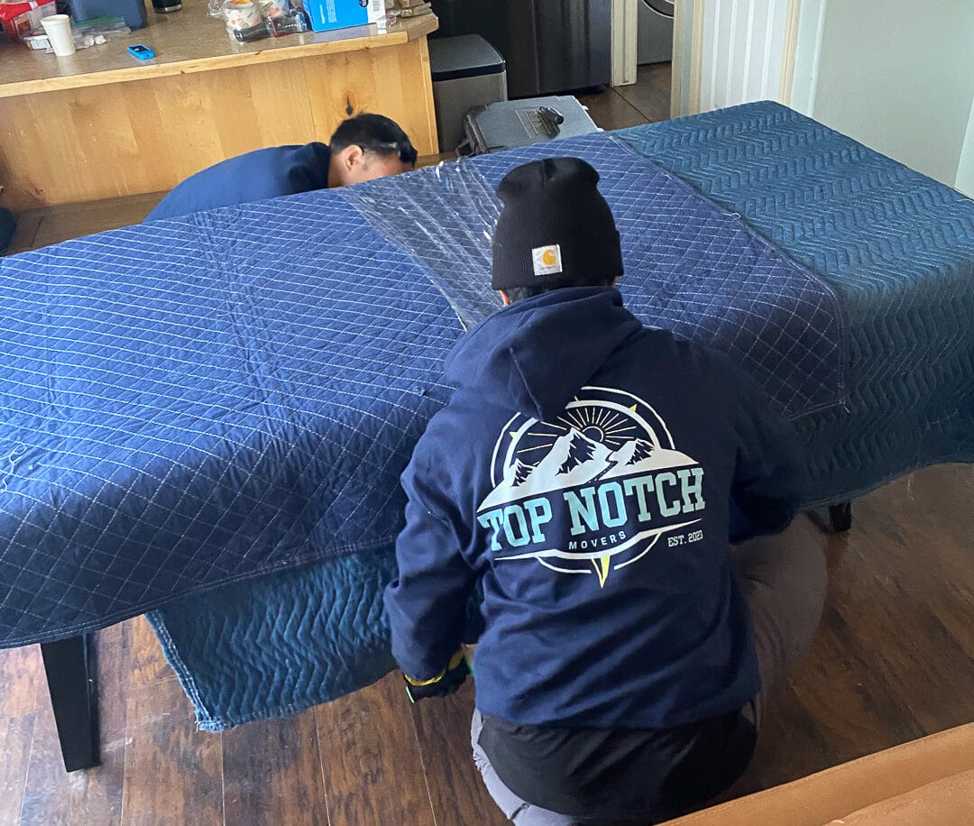 Top Notch crew securing blanket-wrapped furniture