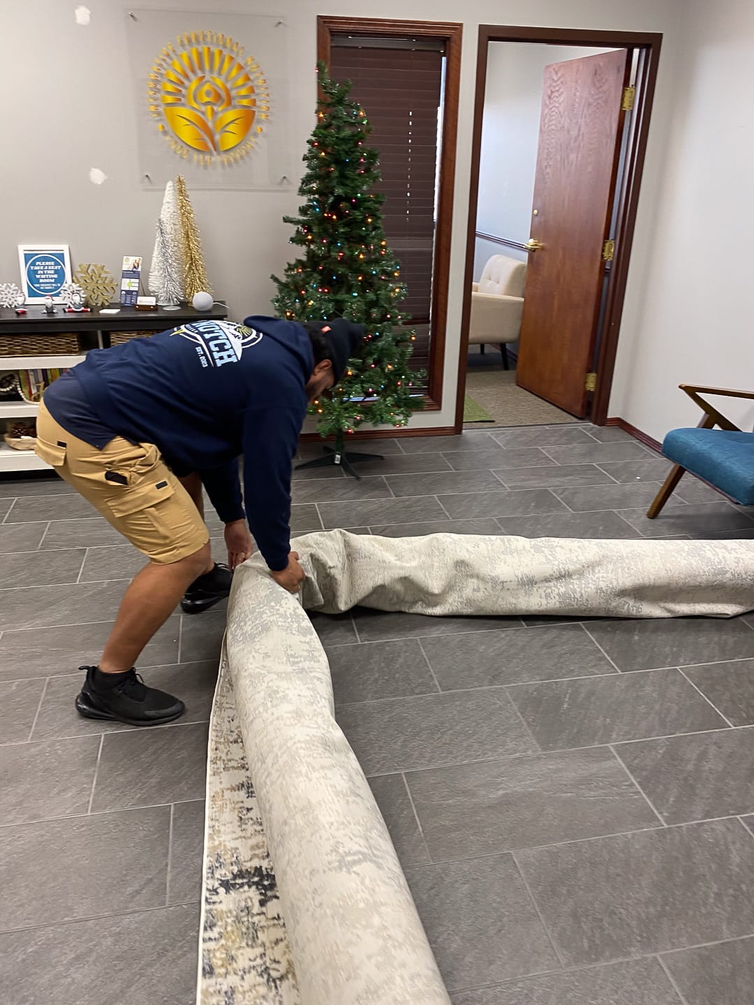 Rolling up the rugs before the furniture goes out